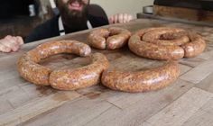 a man sitting at a table with some sausages on it