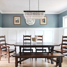 a dining room table and chairs with chandelier hanging from the ceiling over them