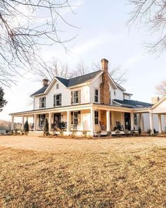 a large white house sitting on top of a grass covered field