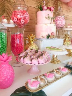 a table topped with lots of pink and green desserts