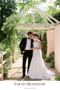 a bride and groom standing under a gazebo