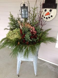 a potted plant with evergreens and other plants in it