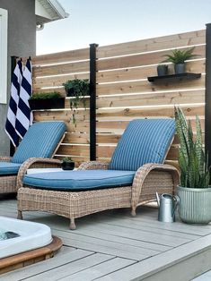 two wicker chaise lounge chairs sitting on a deck next to a hot tub