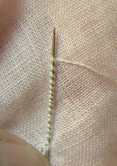 the needle is being used to sew on some material that has been stitched together