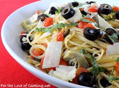 a white bowl filled with pasta and olives