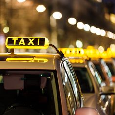 taxi cabs are lined up on the street at night