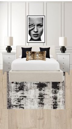 a bedroom with white walls and wood flooring has a leopard print pillow on the bed