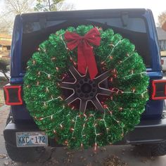 a christmas wreath on the back of a blue jeep