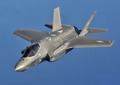 a silver fighter jet flying through the air