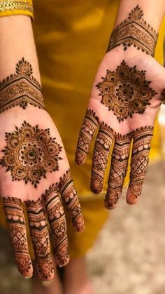 two hands with henna designs on them