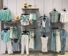 clothes are displayed on shelves in a clothing store