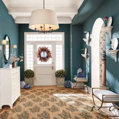 a room with blue walls, white trim and a wreath hanging on the front door