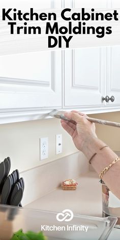 the kitchen cabinet trim moldings diy is being held up by a woman's hand