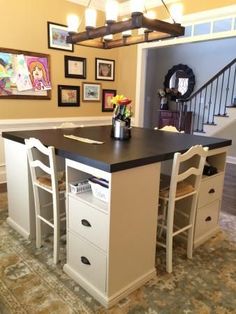 a kitchen island with two stools and pictures on the wall above it that says, awesome diy four station desk