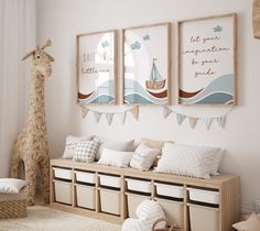 a nursery room with two giraffes hanging on the wall and some storage bins