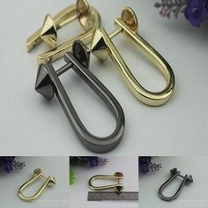 several different types of metal clips and handles on a white surface with flowers in the background