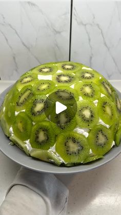 a cake with kiwi slices on it sitting on a plate