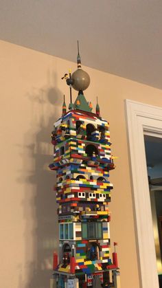 a tall tower made out of legos on top of a wall next to a door