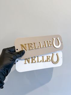 a gloved hand is holding a sign that says nelle u and nielle u