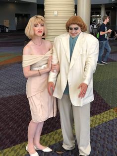 a man and woman dressed in white posing for the camera