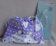 a purple and white polka dot purse next to a package