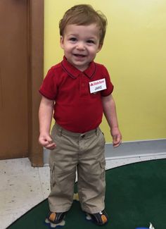 a young boy standing on top of a green floor