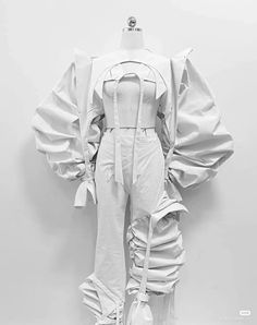 a mannequin dressed in white clothing with large ruffles