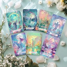 five tarot cards with images of fairy characters on them, surrounded by flowers and rocks