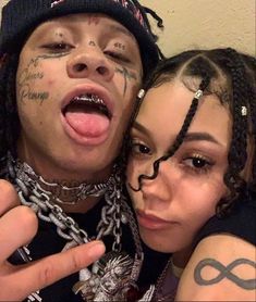 two people with their faces covered in tattoos and piercings posing for a photo together