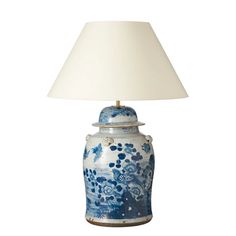 a blue and white vase with a lamp on it