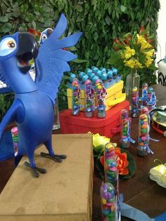 a blue bird figurine sitting on top of a wooden table next to vases