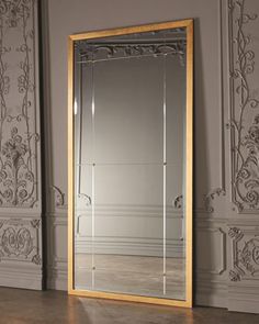 a large mirror sitting on top of a wooden floor