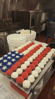 cupcakes with red, white and blue frosting are arranged on a table