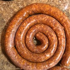 two large sausages sitting on top of a counter next to each other in the shape of a spiral