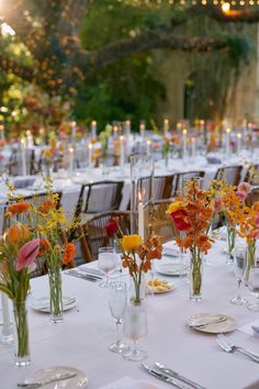 the tables are set with clear vases filled with flowers