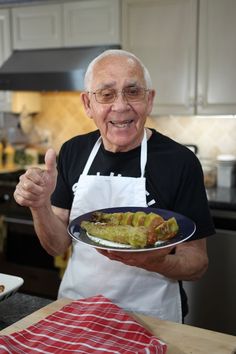 an older man holding a plate with food on it