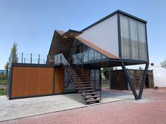 a modern house with stairs leading up to the upper floor and an open roof area