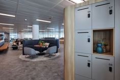 an office with lockers, chairs and tables in the middle of the floor area