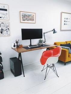 a desk with a computer, chair and other items on it in a white room