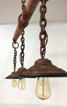 an old fashioned light fixture with chains hanging from it