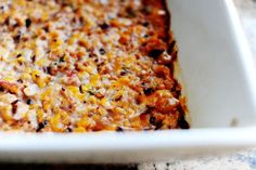 a casserole dish with cheese and other toppings in it on a table