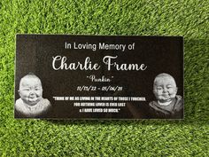 a memorial plaque on the grass with two babies in black and white, which reads in loving memory of charlie frame