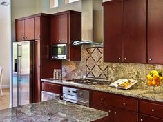 a kitchen with brown cabinets and marble counter tops