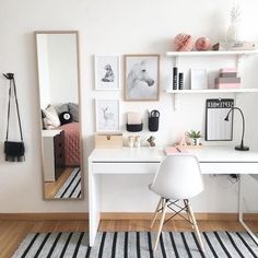 a white desk and chair in a room with pictures on the wall above it,