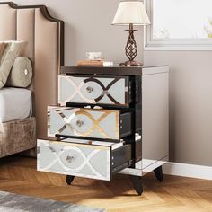 three drawers are stacked on top of each other in front of a bed and nightstand