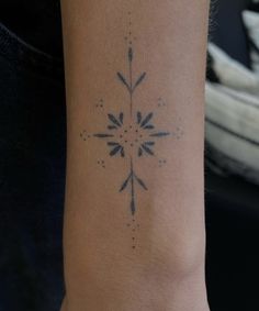 a woman's arm with a tattoo on the wrist and an arrow in the middle