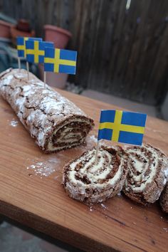 some food that is sitting on a table with flags sticking out of the breads