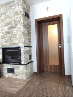 an empty room with a fireplace and wooden floors