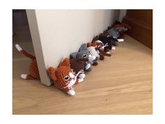 there are many small stuffed animals lined up in a row on the floor next to a wall