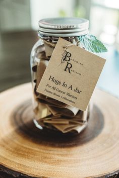 a jar filled with lots of money sitting on top of a wooden table next to a sign